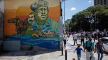 Leute gehen neben einem Wandgemälde des ehemaligen Präsidenten Hugo Chavez und des venezolanischen Präsidenten Nicolas Maduro in Caracas spazieren. Foto: epa/Rayner Pena R