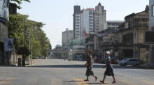 Ein Mädchen überquert eine leere Straße in der Innenstadt von Yangon. Foto: epa/Stringer