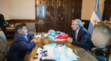 Alberto Fernández (r), Präsident von Argentinien, und Fußballlegende Diego Maradona sitzen im Regierungspalast Casa Rosada gemeinsam an einem Tisch. Foto: Esteban Collazo/Pressestelle Präsidialamt/dpa