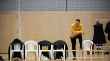 Handball, Europameisterschaft: Cheftrainer Alfred Gislason nimmt an einem Training der deutschen Handball-Nationalmannschaft teil, vor ihm stehen fünf leere Stühle und eine Bank. Foto: Marijan Murat/dpa