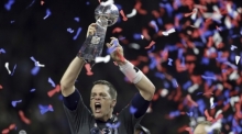 Tom Brady von den New England Patriots jubelt mit der Vince-Lombardi-Trophäe nach dem Sieg gegen die Atlanta Falcons beim NFL-Super-Bowl. Foto: Darron Cummings/Ap/dpa