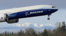Ein Flugzeug vom Typ Boeing 777X startet zu seinem ersten Flug mit den «Olympic Mountains» im Hintergrund in Paine Field. Boeing gibt am 27.10.2021 Zahlen für das 3. Quartal bekannt. Foto: Ted S. Warren/Ap/dpa