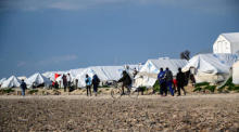 Einwanderer gehen vor ihren Zelten im Flüchtlingslager Karatepe auf der Insel Lesbos spazieren. Foto: epa/Vangelis Papantonis