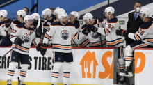 NHL, Winnipeg Jets - Edmonton Oilers, Hauptrunde, North Division, 104. Spieltag. Leon Draisaitl (M) von den Edmonton Oilers feiert sein Tor mit den Teamkollegen auf der Bank. Foto: Fred Greenslade/The Canadian Press/dpa