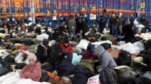 Migranten sind in der Notunterkunft in der Lagerhalle eines Logistikzentrums nahe der Grenze zu Polen. Foto: Ulf Mauder/dpa