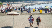 An einem heißen Tag in Neapel verbringen die Menschen Zeit am Strand und auf der Promenade. Foto: epa/Cesare Abbate