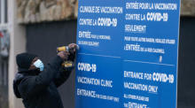 Arbeiter stellen Schilder am ersten Zentrum für die Covid-19-Impfung in Montreal auf. Foto: epa/Andre Pichette