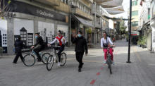 Leute fahren mit ihren Fahrrädern in der Einkaufsstraße von Ledra am ersten Tag der Covid-19-Abriegelung in Nicosia. Foto: epa/Katia Christodoulou