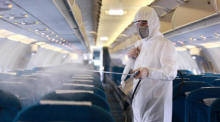 Ein Angestellter sprüht Desinfektionsmittel als Vorsichtsmaßnahme gegen das neuartige Coronavirus im Inneren eines Vietnam Airlines Flugzeugs. Foto: epa/Luong Thai Linh