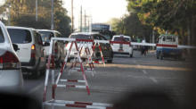 In Yangon fahren Autos durch die Barrikade. Foto: epa/Stringer