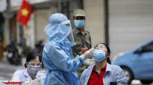 Ein Mitarbeiter des Gesundheitswesens, der eine persönliche Schutzausrüstung (PSA) trägt, entnimmt einer Frau in Hanoi Abstrichproben zur Untersuchung auf das Coronavirus (COVID-19). Foto: epa/Luong Thai Linh