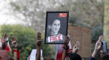 Ein Porträt der inhaftierten Staatsrätin Aung San Suu Kyi wird von Demonstranten gehalten. Foto: epa/Stringer