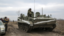 Ein Mann filmt ein gepanzertes Fahrzeug in der von prorussischen Kämpfern kontrollierten Region Donezk im Osten der Ukraine. Foto: Uncredited/Ap/dpa