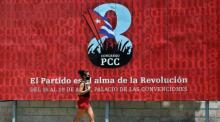 Eine Frau geht vor einem Banner, das für den VIII. Kongress der Kommunistischen Partei Kubas (PCC) wirbt, der vom 16. bis 19. April in Havanna stattfindet. Foto: epa/Ernesto Mastrascusa