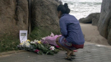 Eine Dorfbewohnerin legt am Tatort, dem weltbekannten Sairee Beach auf Koh Tao, Blumen nieder.