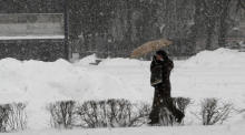 Ein Frau geht bei Schneefall in Riga, Lettland, spazieren. Foto: epa/Toms Kalnins