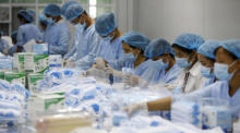 Arbeiter an einer Produktionslinie für medizinische Gesichtsmasken in der "Green Mask"-Fabrik in Hai Duong, inmitten der andauernden Covid-19-Pandemie. Foto: epa/Luong Thai Linh