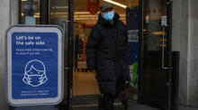 In London geht ein Mann an einem Schild mit Hinweisen zur Covid-19-Prävention vorbei. Foto: epa/Neil Hall