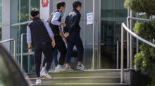 Der Apple Daily-Chefredakteur Ryan Law (R) wird von der Polizei zum Büro von Next Media, dem Herausgeber von Apple Daily, in Hongkong eskortiert. Foto: epa/Jerome Favre
