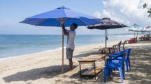Der Mann stellt Sitzgelegenheiten an einem Strand in Kuta, Bali, auf. Foto: epa/Made Nagi