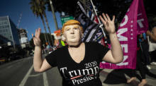Ein Trump-Befürworter trägt eine Trump-Maske, als Pro-Trump-Demonstranten zur Unterstützung von US-Präsident Donald Trump vor dem Rathaus in Los Angele demonstrieren. Foto: epa/Etienne Laurent