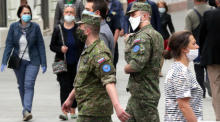 Im Zentrum von Sarajevo gehen Soldaten aus der Slowakei und Bosnien und Herzegowina mit Schutzmasken auf die Straße. Foto: epa/Fehim Demir