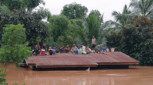 Laotische Dorfbewohner sind auf einem Dach gestrandet, nachdem der Xe Pian Xe Nam Noy Damm zusammengebrochen ist. Foto: epa/ABC Laos News