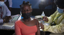 Eine junge Frau reagiert, als sie am 21.10.2021 im Township Diepsloot in der Nähe von Johannesburg eine Impfung mit dem Impfstoff von Pfizer/Biontech gegen Covid-19 erhält. Foto: Denis Farrell