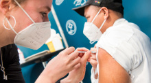 Ein Besatzungsmitglied des Aida-Kreuzfahrtschiffes "Aida prima" wird im Cruise Center Steinwerder während einer Impfaktion mit dem Impfstoff von Moderna geimpft. Foto: Daniel Bockwoldt/dpa