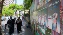 Frauen gehen in Beirut an politischen Plakaten vorbei, die sich gegen die USA und Israel richten. Foto: epa/Wael Hamzeh