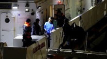 In Bari steigen Migranten auf dem Rückweg von Albanien aus einem Patrouillenboot aus. Foto: epa/Donato Fasano