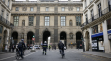 Polizeibeamte stehen vor dem Louvre Wache, nachdem das Museum wegen einer Bombendrohung geräumt wurden. Foto: Thomas Padilla/Ap/dpa