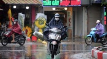 Motorradfahrer trotzen dem Regen in Hanoi, wo Taifun Wipha am 22. Juli auf Land treffen soll. Foto: epa/Luong Thai Linh