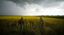 Russische Soldaten bewachen ein Gebiet neben einem Weizenfeld, während ausländische Journalisten arbeiten, in einem Gebiet unter russischer Militärkontrolle. Foto: Uncredited
