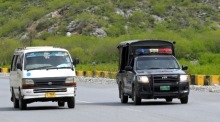 Unter Polizeibegleitung fahren Fahrzeuge mit afghanischen Migranten über die Bergstraße nahe Torkham zur Grenze, wo Pakistan die Rückführung organisiert. Foto: EPA/Bilawal Arbab