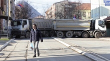 Ein Anwohner geht an Lastwagen vorbei, die die Straße im nördlichen Teil von Mitrovica blockieren. Foto: EPA-EFE/Str