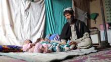 Ein Vater von neugeborenen Drillingen, Ehsanullah, sitzt neben seinen Babys in seinem Haus in Kandahar. Foto: epa/Str