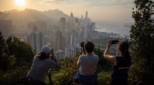 Fotografiebegeisterte fotografieren die untergehende Sonne über der Insel Hongkong in Hongkong. Foto: epa/Jerome Favre