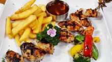 Gegrillte Chicken-Wings am Spieß mit Barbecuesauce, knusprigen Pommes Frites und buntem Grillgemüse. Fotos: Jaybee'Swiss Restaurant