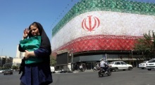 Iraner gehen an einer Flaggen-Werbetafel in Teheran vorbei, nachdem US-Präsident Trump ein baldiges Abkommen in Aussicht gestellt hat. Foto: epa/Abedin Taherkenareh