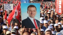 Eine Person hält ein Foto des ehemaligen Istanbuler Bürgermeisters Ekrem Imamoglu in den Händen, während Anhänger der Republikanischen Volkspartei (CHP) der Türkei daneben stehen. Foto: epa/Necati Savas