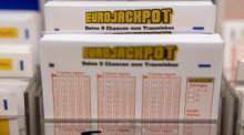 Eurojackpot-Spielscheine stehen in einem Regal in einer Lotto-Annahmestelle. Foto: Thomas Banneyer/dpa