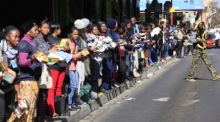 Einige der hunderten von Menschen bilden eine Menschenkette, um gespendete Lebensmittel und Kleidung zu einer nahe gelegenen Notunterkunft in der Innenstadt von Johannesburg zu bringen. Foto: epa/Kim Ludbrook