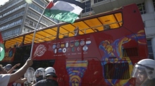 Ein Tourist in einem Bus reagiert auf Demonstranten im Hafen von Piräus, die gegen die Ankunft eines Kreuzfahrtschiffs protestieren. Foto: epa/Yannis Kolesidis
