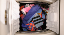 Bunte Socken liegen in der Trommel einer Waschmaschine. Foto: Robert Michael/dpa