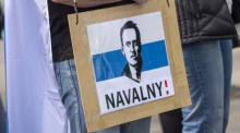 Ein Mann trägt ein Schild mit dem aufgedruckten Gesicht von dem gestorbenen Regimegegner Alexej Nawalny. Foto: Thomas Banneyer/dpa
