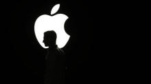 Ein Mensch läuft vor dem Apple-Logo. Foto: epa/Monica Davey