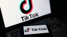 Das Logo der TikTok-Plattform auf einem Smartphone und Laptop. In Großbritannien wird ein mögliches Social-Media-Verbot für unter 16-Jährige diskutiert. Foto: EPA/Adam Vaughan