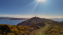 Ein Mensch wandert in Eastbourne in Wellington (Neuseeland) bei Sonnenschein an der Küste entlang. Ein starkes Erdbeben der Stärke 6,7 hat die Küste der Südinsel Neuseelands erschüttert. Foto: Guo Lei/Xinhua/dpa
