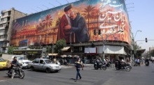 Menschen fahren in Teheran an einem Plakat mit dem verstorbenen iranischen Revolutionsführer Ali Khamenei vorbei. Foto: EPA/Abedin Taherkenareh